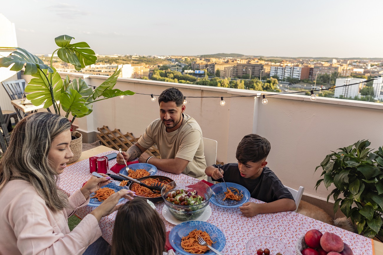 Family enjoying dinner on balcony.