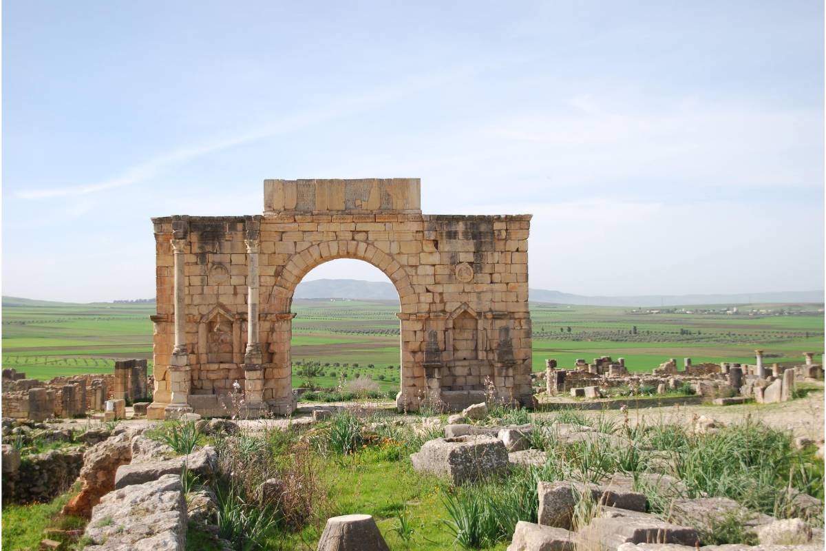 Ancient stone arch in green landscape